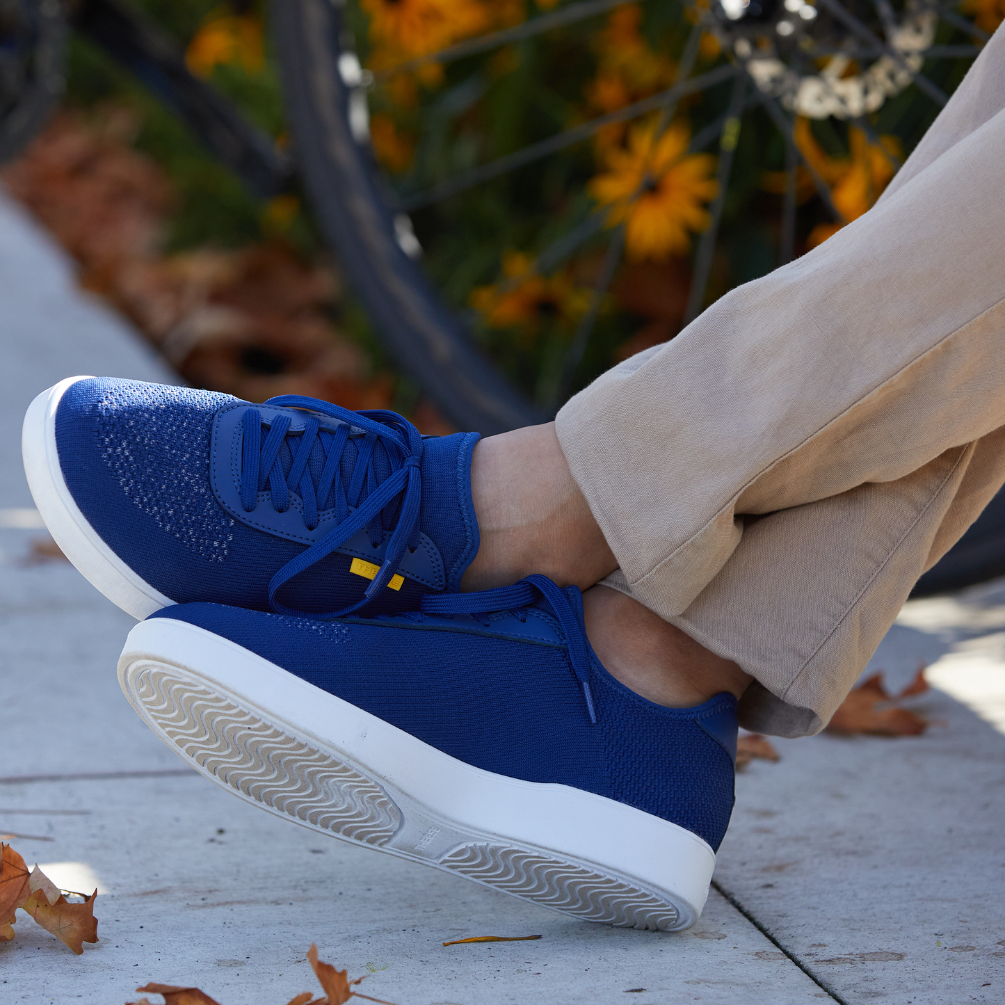 Waterproof Blue sneakers with white soles worn by a person on a wooden surface