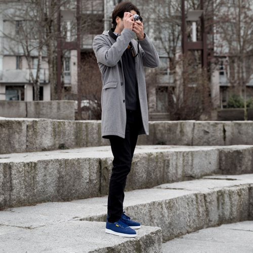 Man taking a photo with a camera on stone steps outdoors